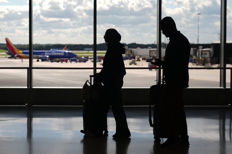 Travelers walk through the Baltimore/Washington International Thurgood Marshall Airport, Thursday, Oct. 2, 2025, in Baltimore. (AP Photo/Stephanie Scarbrough)