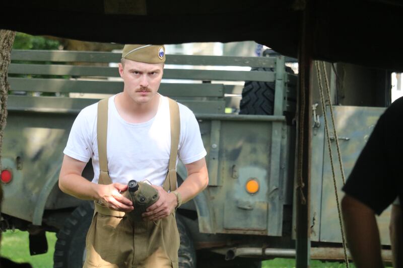 James Dreska enters an encampment with a water canteen in hand Saturday, Aug. 2, 2025, during a living history military encampment staged outside the Genoa Veterans Home in Genoa. The demonstration was part of Veterans Weekend.