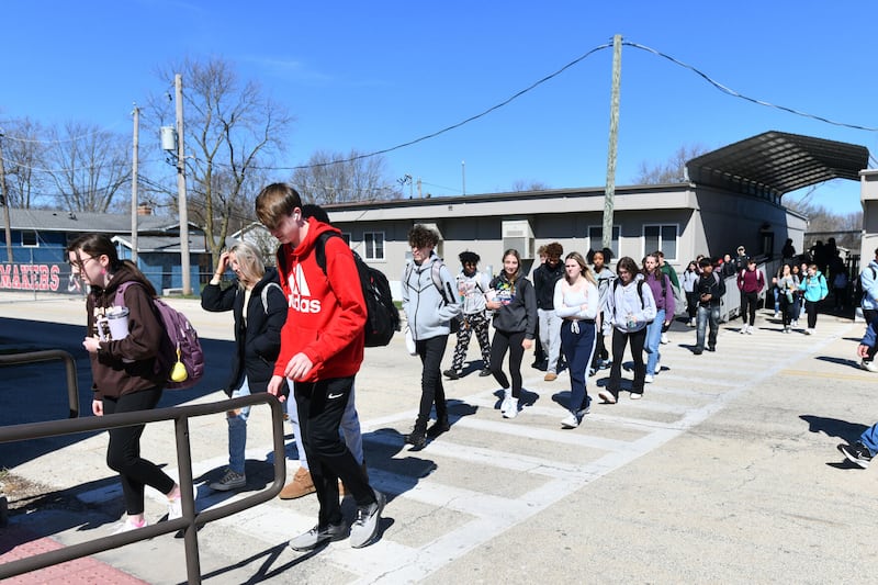 Students return to the main building from mobile classrooms during a passing period at Bradley-Bourbonnais Community High School in March 2024.