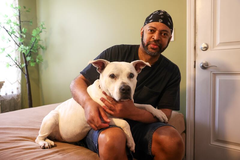 EF Ellington, of Hopkins Park, sits with his dog, Mz. CC, after recently being reunited after she had been missing for six years.