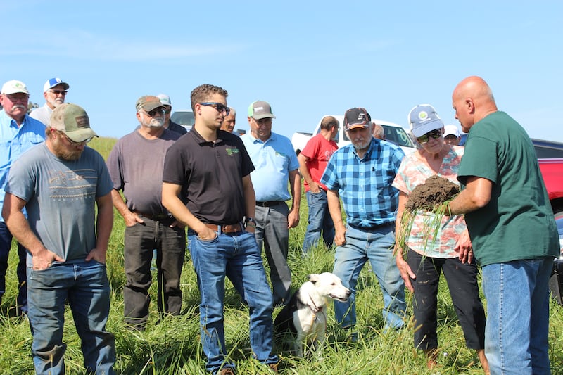 Greg Thoren (far right) shows those attending the Nutrient Stewardship Field Day the characteristics of the soil where he is growing cover crops on his Jo Daviess County farm in northwestern Illinois. The farmer seeded about nine acres with the multi-species mix to improve this tough section of the field and his cattle will graze this area using a virtual fencing system.