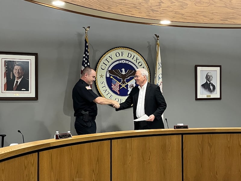 Dixon Mayor Glen Hughes shakes hands with Deputy Chief Doug Lehman after swearing him in as interim police chief at Monday's Dixon City Council meeting, May 5, 2025.