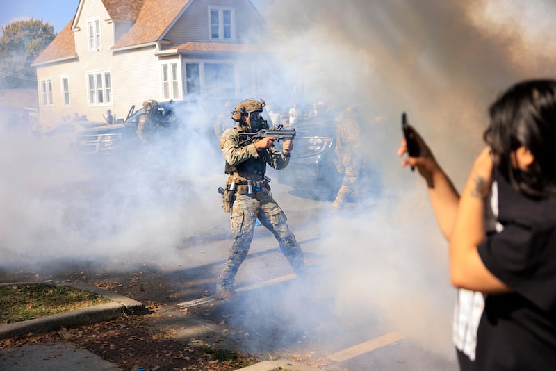 A U.S. Customs and Border Protection agent points a non-lethal weapon at protesters in East Side, Chicago, Tuesday, Oct. 14, 2025. (Anthony Vazquez/Chicago Sun-Times via AP)