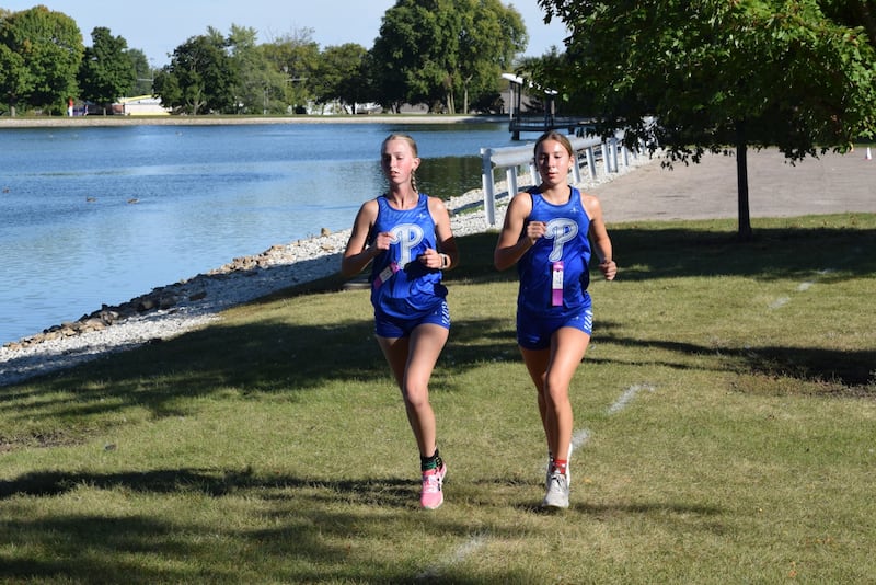 Princeton's Payton Frueh (left) and Ruby Acker run in Wednesday's meet at Lake Mendota. Acker finished first and Frueh was second.