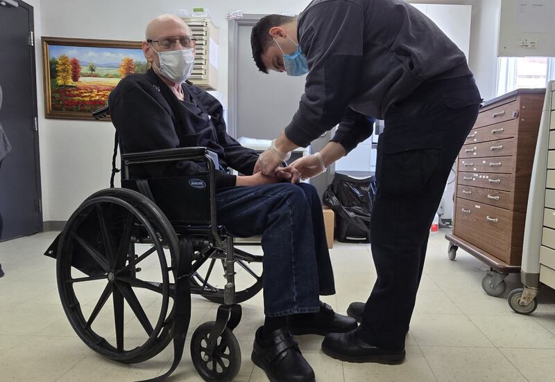 Kyle Albert, McHenry County College student in the paramedic certification program, assists a resident at Sheltered Village in Woodstock as part of his clinical rotation.
