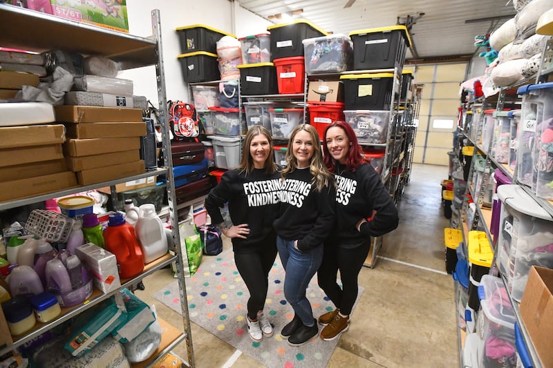 Foster moms Rachel Langlois, right, of Kankakee, Mallory Handford, center, and Allie Brooks, both of Bourbonnais, stand in the area of Langlois' shed that houses hundreds of donations for Georgie's Closet, which provides children in foster care and their foster families in Kankakee County with clothing and essential items.