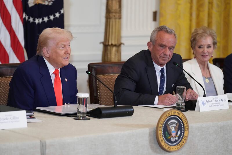 President Donald Trump, left, speaks as Education Secretary Linda McMahon, right, and Health and Human Services Secretary Robert F. Kennedy Jr. listen at a Make America Healthy Again (MAHA) Commission Event in the East Room of the White House, Thursday, May 22, 2025, in Washington. (AP Photo/Jacquelyn Martin)