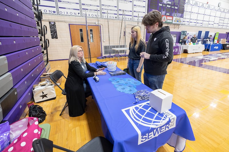 Hilary Johnson, benefits specialist at Sewer Equipment Co. of Dixon, speaks with Trinity Keener of Dixon and Mathew Call of Polo Wednesday, March 13, 2024 at the Discover Dixon career fair.