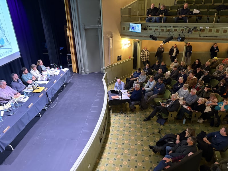 Jack Pease, seated at a table to the right of the stage, speaks about a proposed gravel pit during a Woodstock Plan Commission meeting Jan. 15, 2026.