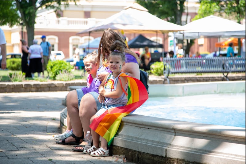 Residents take a seat by the fountain at Washington Park during the annual Ottawa Pride Fest.