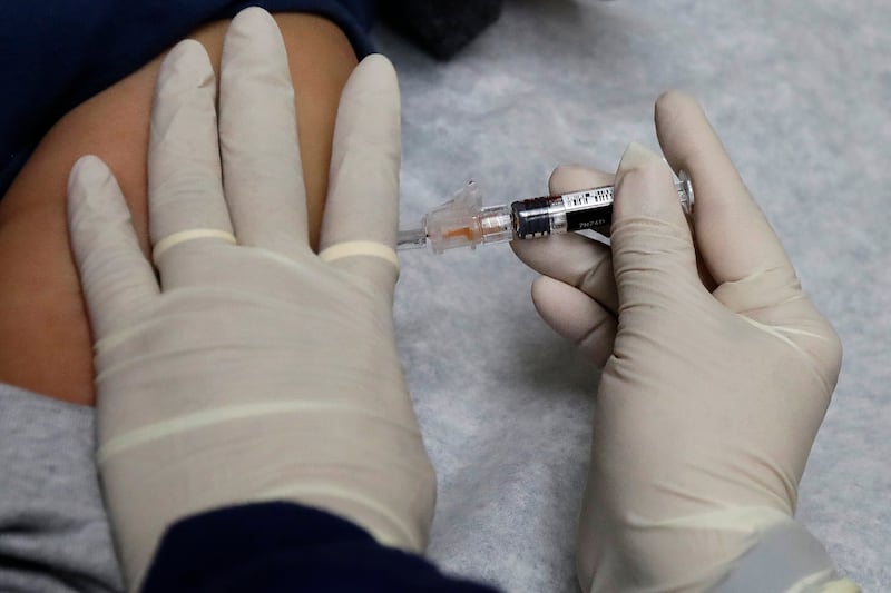 A medical assistant at a community health center gives a patient a flu shot.
