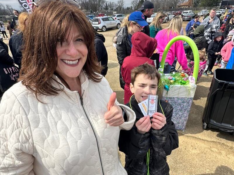 Dawn Bremer gives a thumbs up as one of the special prize winners shows off his take during the Bremer Team Easter Egg Hunt in 2024. The second annual event is set for Saturday, April 12, at the McHenry Outdoor Theater.