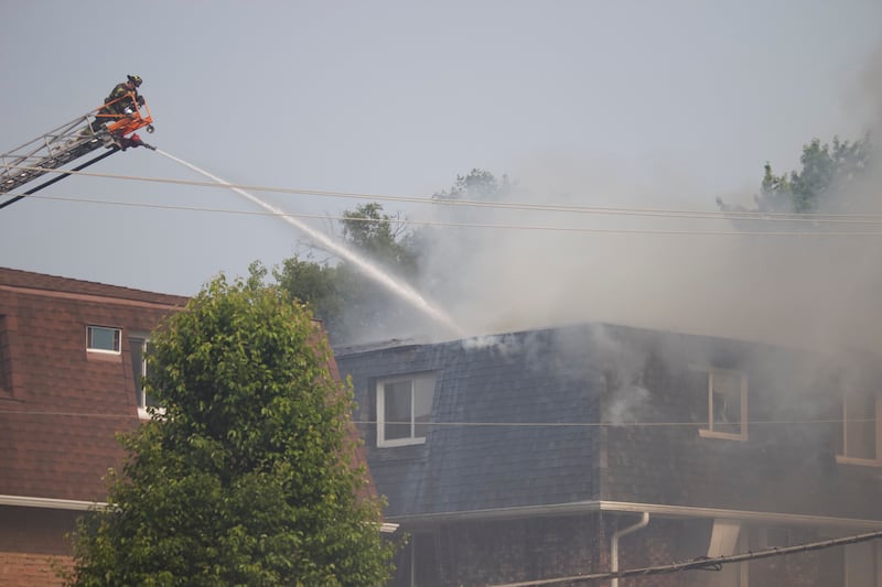 A Joliet firefighter dousing an apartment building with water to put out a fire on Tuesday, June 10, 2025, near Essington Road in Joliet.