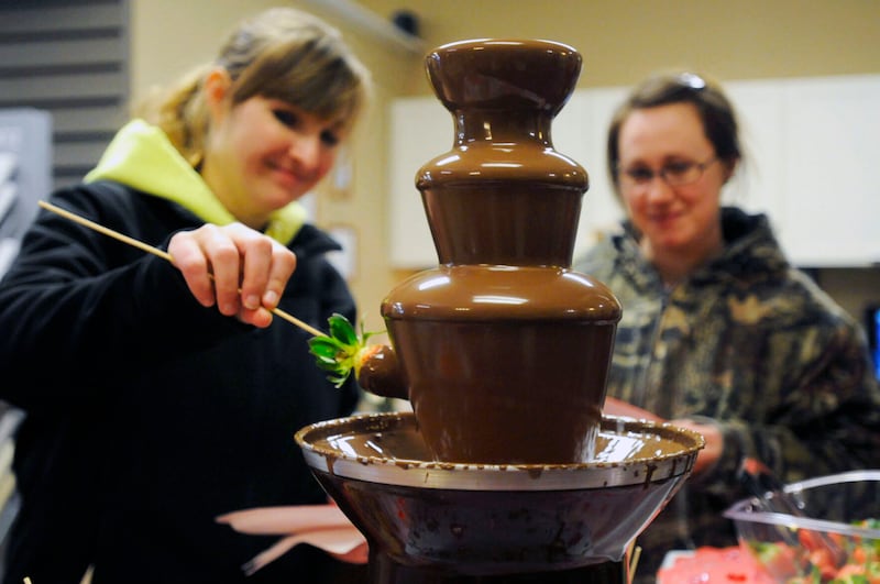 Two attendees dip strawberries in a chocolate fountain during the village of Bourbonnais’ second annual Chocolate Tour in 2018. The event returns in February and registration is open through Dec. 13 for businesses to sign up to be a tour stop.
