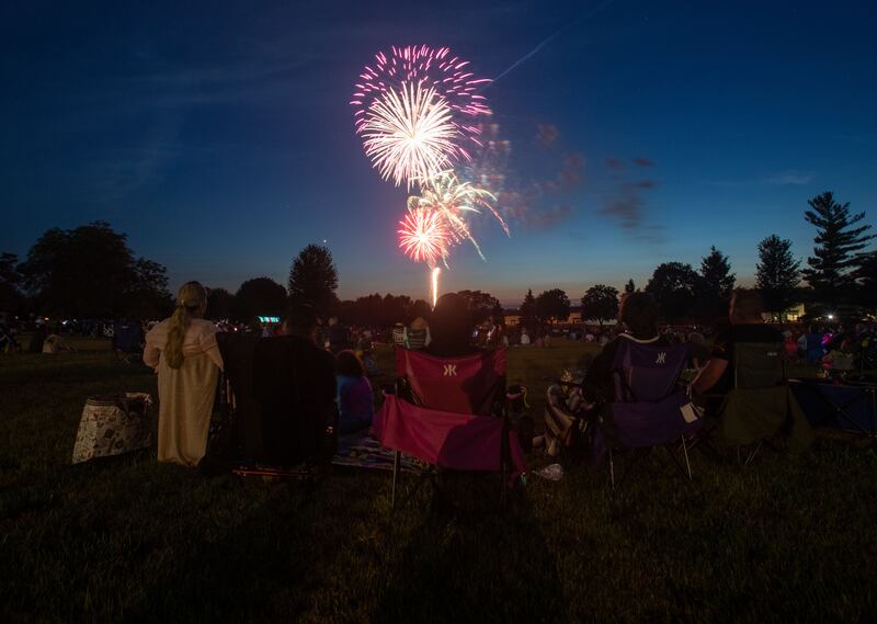 Attendees sit and watch the Elburn Lions Club Fireworks at Lions Park in Elburn on Saturday, July 8, 2023.
