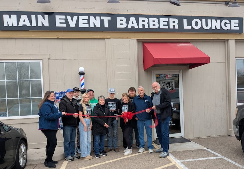 Carrie Troha, owner of Main Event Barber Lounge, cut the ribbon at her new business at 102 E. Hitt St., Mt. Morris, joined by members of the Mt. Morris Village Board, the Economic Development Corporation and her children.