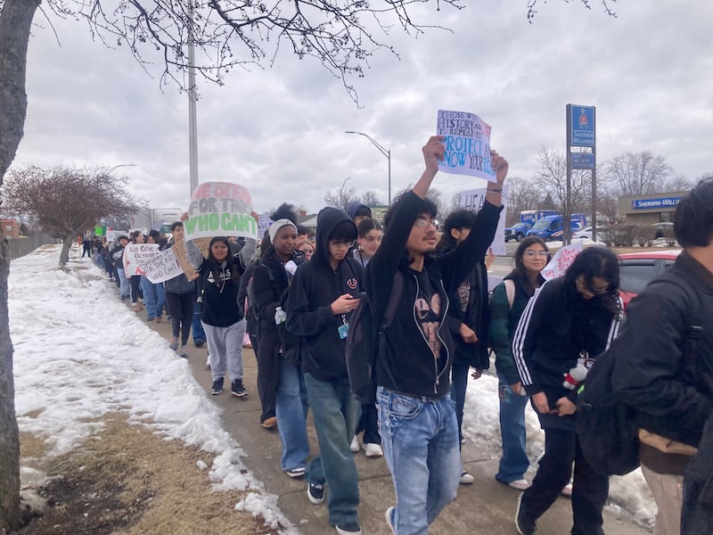 Students from Joliet West High School hold signs as they march down Larkin Avenue after walking out of school to protest the actions of Immigration and Customs Enforcement agents on Friday, Feb. 6, 2026.