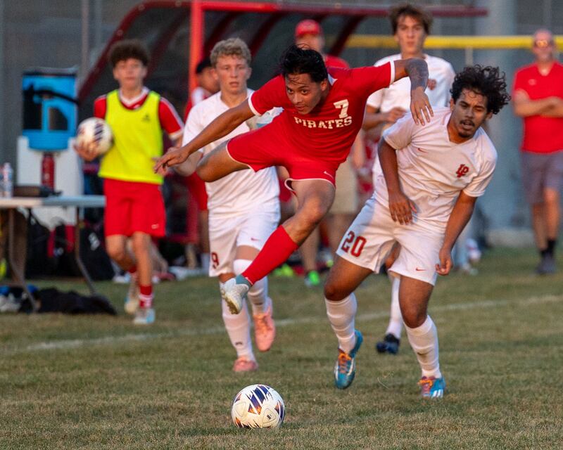 (from left) Jorge Lopez (7) of Ottawa jumps over Noah Escobedo (20) of L-P on Wednesday, Sept. 17, 2025 at Ottawa High School in Ottawa.