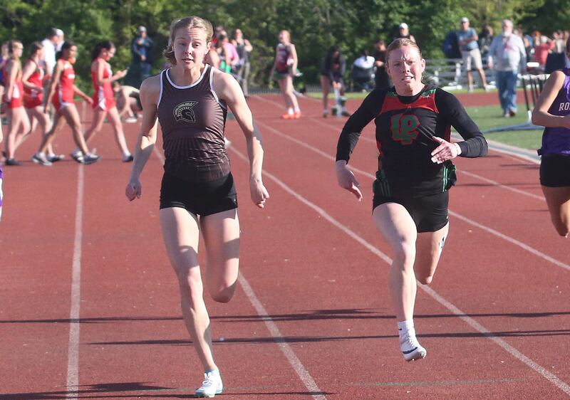 Sycamore's Alyssa Stacy and L-P's Elli Sines compete in the 100 meter dash during the Interstate 8 Conference girls track championship on Friday, May 9, 2025 at Morris High School.