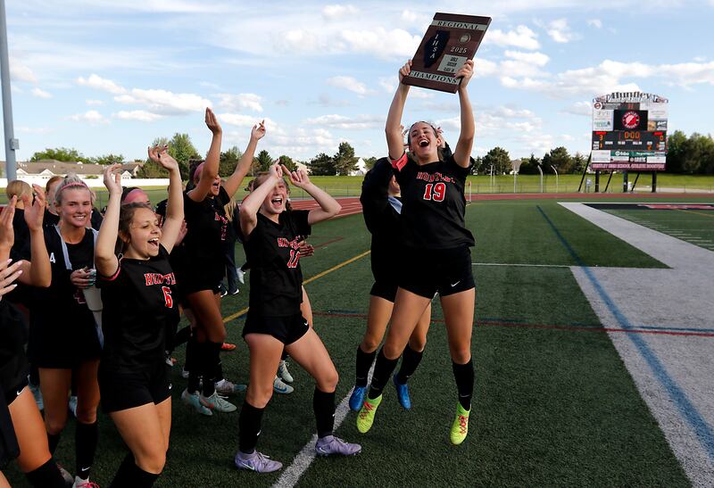 Huntley's Jaci Laramie raises the trophy as she celebrates Huntley’s win over Jacobs   in the IHSA Class 3A Huntley Girls Soccer Regional championship match on Friday, May 23, 2025, at Huntley High School.
