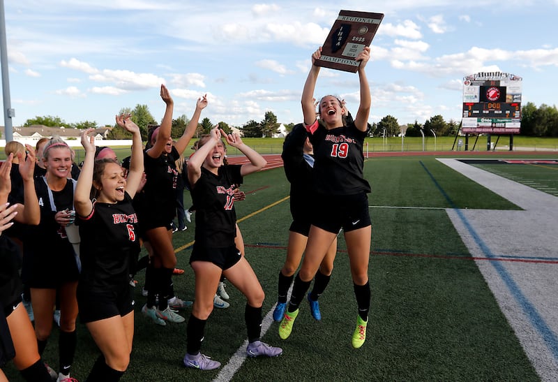 Huntley's Jaci Laramie raises the trophy as she celebrates Huntley’s win over Jacobs in the IHSA Class 3A Huntley Girls Soccer Regional championship match on Friday, May 23, 2025, at Huntley High School.