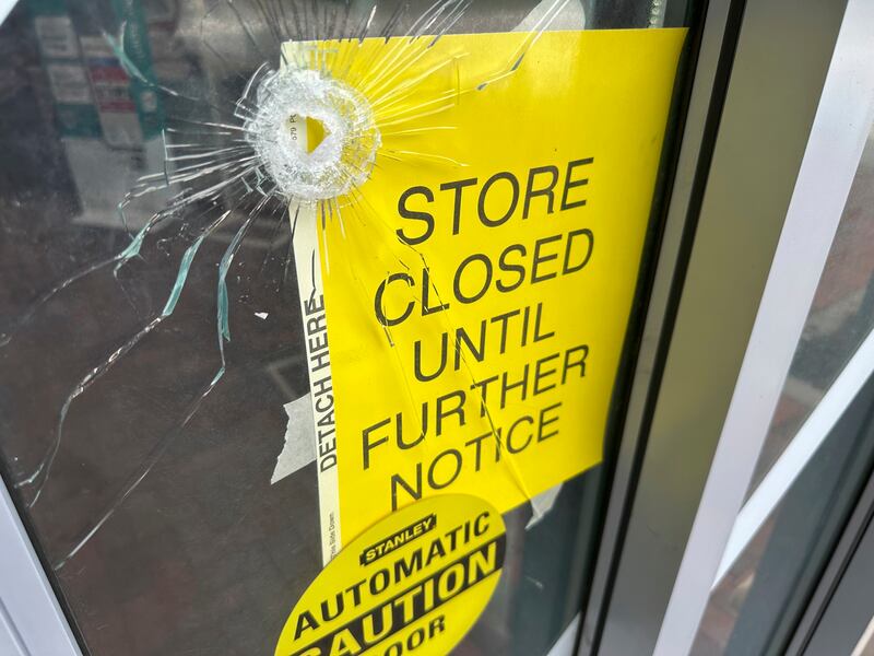A bullet hole is visible in the door of a CVS pharmacy on Saturday, Aug. 9, 2025, near where police say a man was shooting at the headquarters of the U.S. Centers for Disease Control and Prevention in Atlanta.