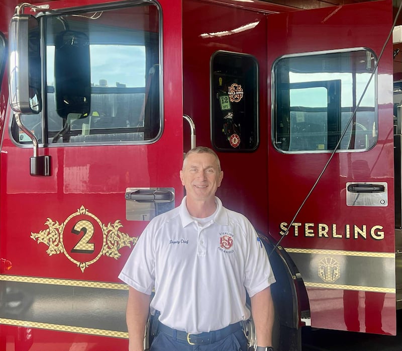 Scott Melton, newly sworn in as deputy fire chief for the Sterling Fire Department, stands in front of a fire engine at the station on Oct. 2, 2025.