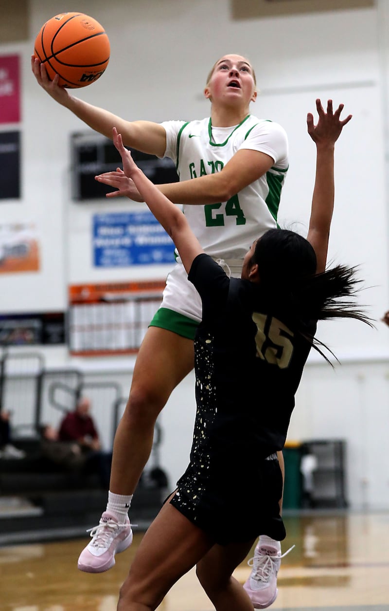 Crystal Lake South's Gracey LePage drives to the base over Grayslake North's Mia Leilani Gumapas during a Northern Illinois Holiday Classic semifinal girl basketball game on Tuesday, Dec. 16, 2025, at McHenry High School.