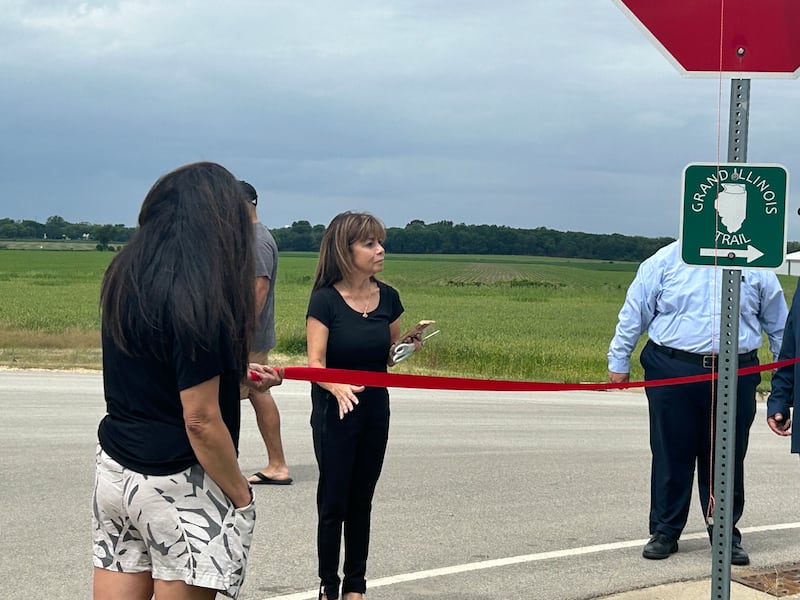 Harvard Alderwoman Rosa Luna, 4th Ward, cuts ribbon on Saturday, June 8, 2024, during the ceremony naming the entrance to Milky Way Park after her father, V.H. Garza. The Garza family was one of the first Spanish-speaking families in Harvard.