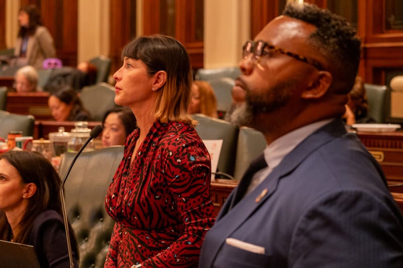 Reps. Eva-Dina Delgado and Kim Buckner watch the House of Representatives discuss their proposal to reform Chicagoland public transit. The two Chicago Democrats led a House working group tasked with overseeing negotiations.