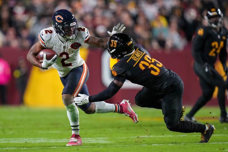 Chicago Bears wide receiver DJ Moore (2) stiff arms Washington Commanders safety Jeremy Reaves (39) during the first half of an NFL football game Monday, Oct. 13, 2025, in Landover, Md. (AP Photo/Stephanie Scarbrough)