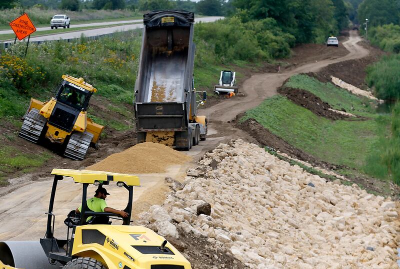 Work continues on a walking path around the lake at Three Oaks Recreation Area on Thursday, July 24, 2025, near the intersection of Pingree and James R. Rakow roads. When all the construction is complete there will be a 3.1 mile loop around the lake.