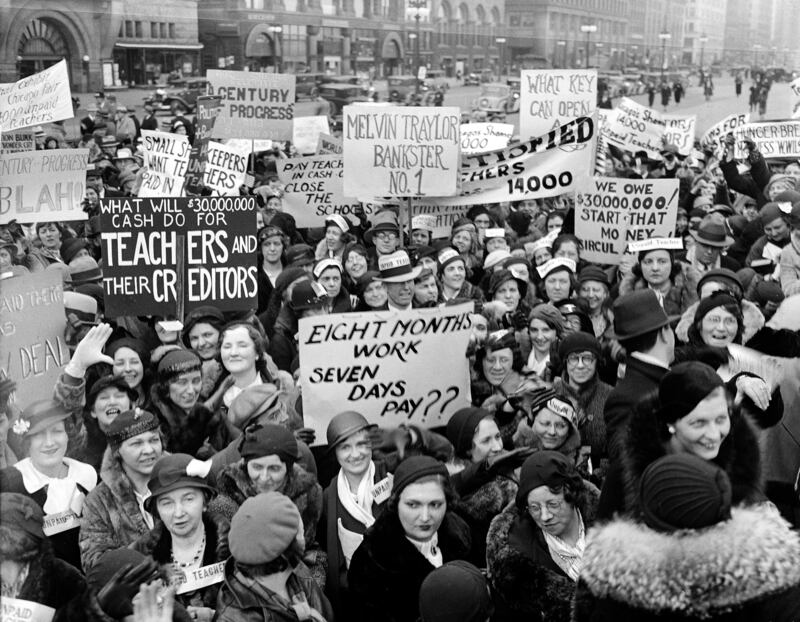 Unpaid school teachers storm the official World's Fair flag-raising ceremony on April 10, 1933, in Chicago, demanding that the Century of Progress should not go on until they are given their back pay. One banner reads: "Eight Months Work – Seven Days Pay??" referring to the long period that Chicago teachers have gone unpaid for their work.