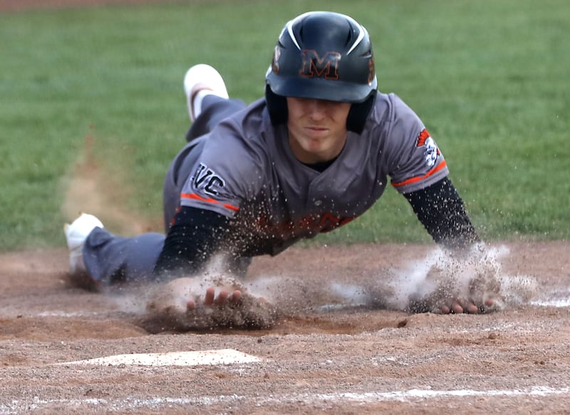 McHenry's Landon Clements slides into home plate to score a run during a Fox Valley Conference baseball game against Huntley on Tuesday, May 8, 2026, at Huntley High School.