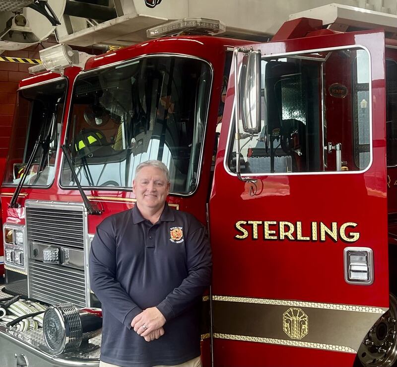 Newly appointed Fire Chief David Northcutt stands besides a fire engine at the Sterling Fire Department.