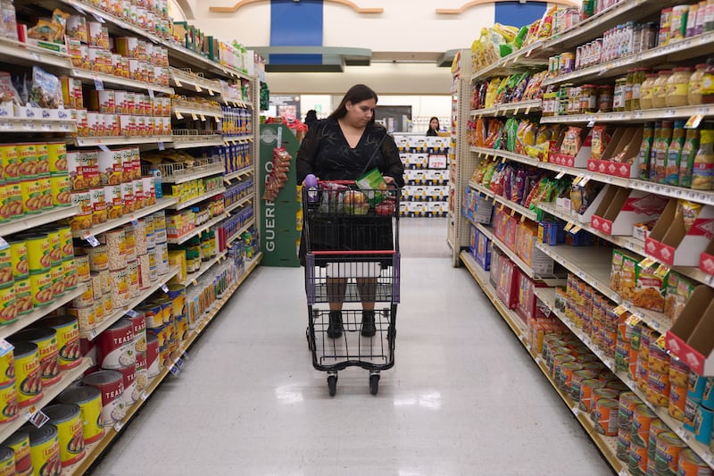 FILE - Jaqueline Benitez pushes her cart down an aisle as she shops for groceries at a supermarket in Bellflower, Calif., on Monday, Feb. 13, 2023. (AP Photo/Allison Dinner, file)
