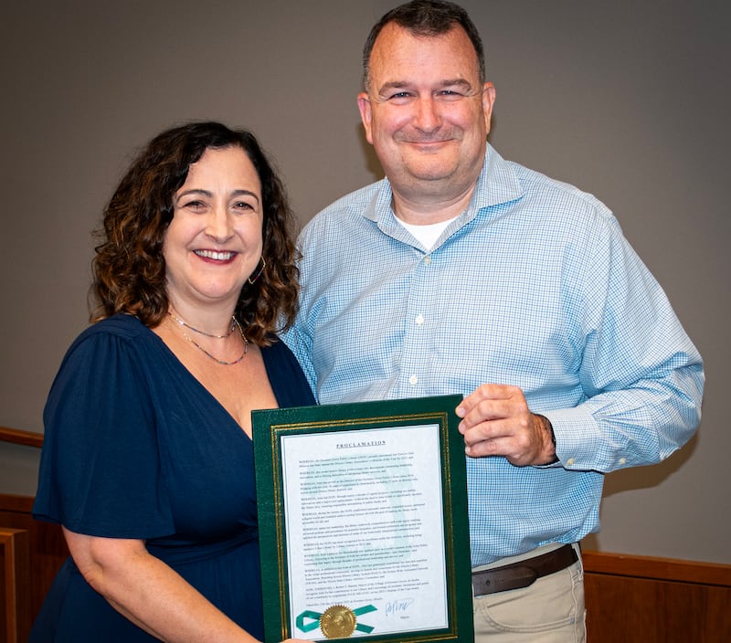Downers Grove Public Library Director Julie Milavec receives a plaque from Mayor Bob Barnett recognizing her as the 2025 Illinois Library Association Librarian of the Year.