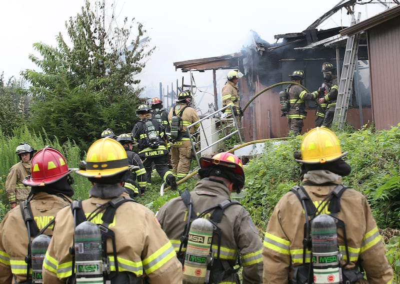 Firefighters work the scene of a fully-engulfed structure fire in the 500 block of North 2782nd Road on Monday, July 21, 2025 in La Salle. FIre departments from Utica, Wallace, Naplate, Spring Valley, Mendota, Troy Grove, La Salle, Peru, Oglesby and Tonica responded to the scene. Fire crews were dispatched at 9:45 a.m. La Salle Police and La Salle County Sheriff were also on the scene.