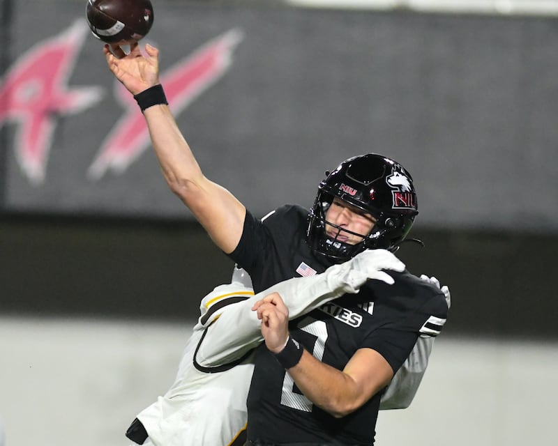 Northern Illinois University's quarterback Brady Davidson (2) throws an incomplete pass as Western Michigan’s defender Jarvarius Sims wraps him up during the game on Tuesday Nov. 18, 2025, held at Huskie Stadium in DeKalb.