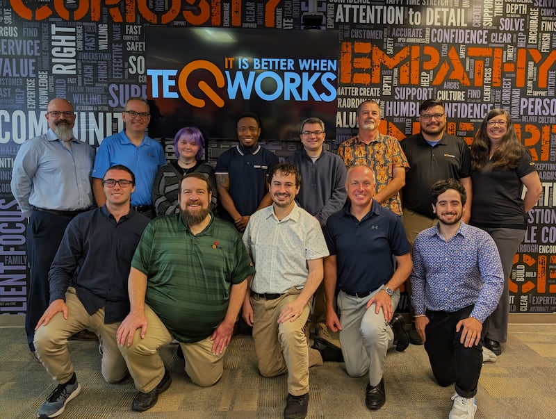 Employees of Teqworks, a St. Charles-based IT services and consulting business, in front of the company's "core values wall" at their new offices at 3815 E. Main St., a move announced in June 2025.