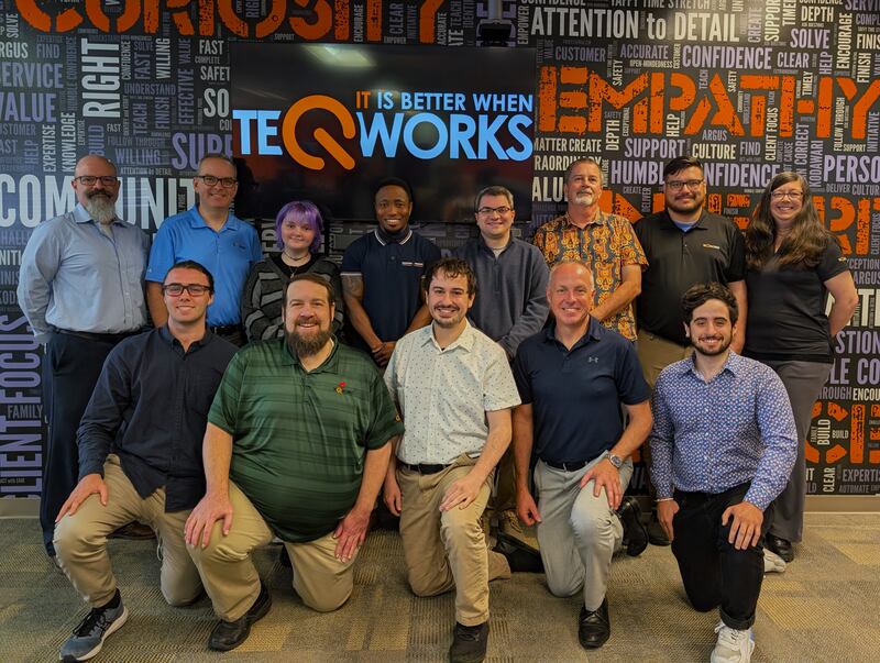Employees of Teqworks, a St. Charles-based IT services and consulting business, in front of the company's "core values wall" at their new offices at 3815 E. Main St., a move announced in June 2025.