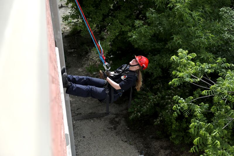 Geneva Fire Recruit Kelly Hunecke rappels down the side of the Third Street Commuter Parking Deck during a training exercise on Tuesday, May 13, 2025 in Geneva.