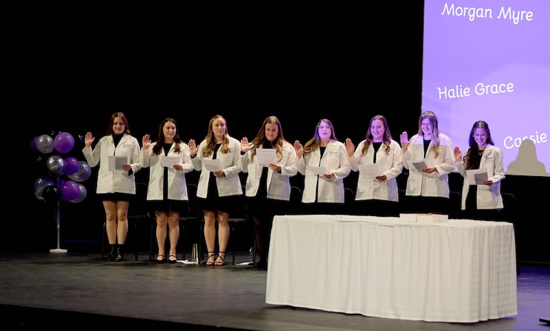 The first class of eight dental hygiene students to graduate from Illinois Valley Community College accepted white lab coats and lapel pins to signify their entry into the field during a ceremony on December 12, 2025.