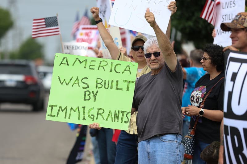 A protester holds a sign along West Jefferson Street for the No Kings Day protest on Saturday, June 14, 2025 in Joliet.