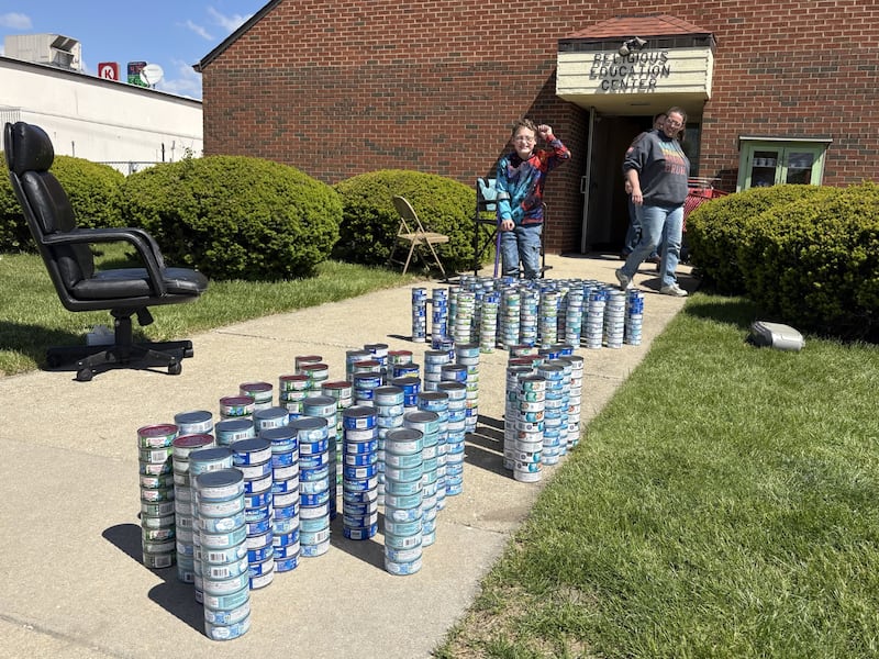Maximilian Claahsen poses for a photo in front of 1,350 donated tuna cans following his annual birthday food drive Saturday, May 2, at the Marseilles Food Pantry.