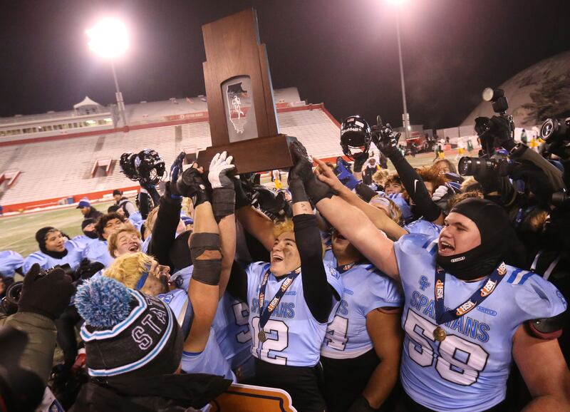 Members of the St. Francis football team hoist the Class 5A State championship trophy on Tuesday, Dec. 2, 2025 in Hancock Stadium at Illinois State University in Normal.