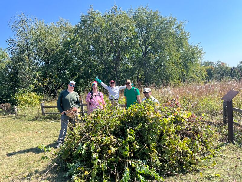 Cary Prairie Stewards (from left to right) Mike Burke, Ruth Krevitt, Ellie Krall, Jay Krall and Jacob Karkowski standing behind a pile of invasive brush cleared from Hillside Prairie in Cary on Sept. 28th, 2025.