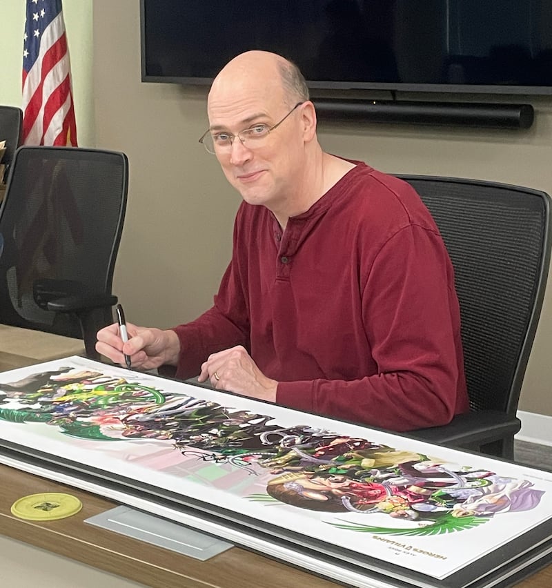 Artist Alex Ross signs his artwork that will be sold in the gift shop at the Dunn Museum in Libertyville.