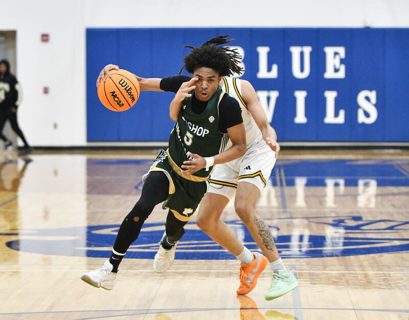Bishop McNamara's Willie Felton keeps his eye on the basket as Joliet Catholic Academy's JJ Sterrett attempts to swat the ball away during the Fightin' Irish's 79-67 victory over the Hilltoppers in the IHSA Class 2A Peotone Sectional semifinal on March 4, 2025.
