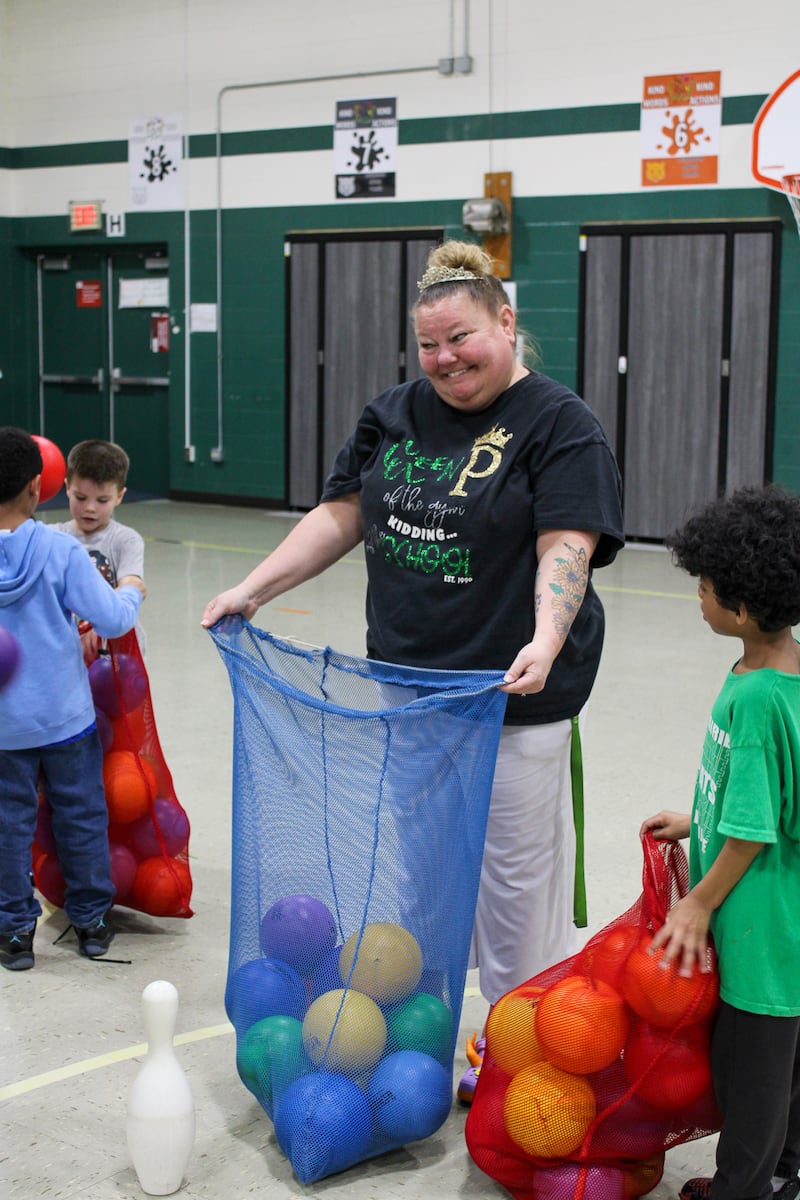 Grand Prairie Elementary School students assist Andrea Paplaski-Grygiel to put away equipment after class.
